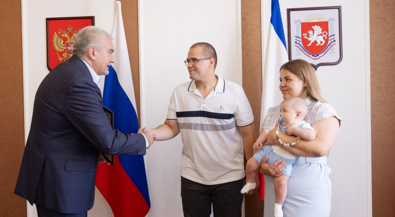 Сергей Аксёнов вручил молодой семье Орловых важный документ. Фото с сайта glava.rk.gov.ru
