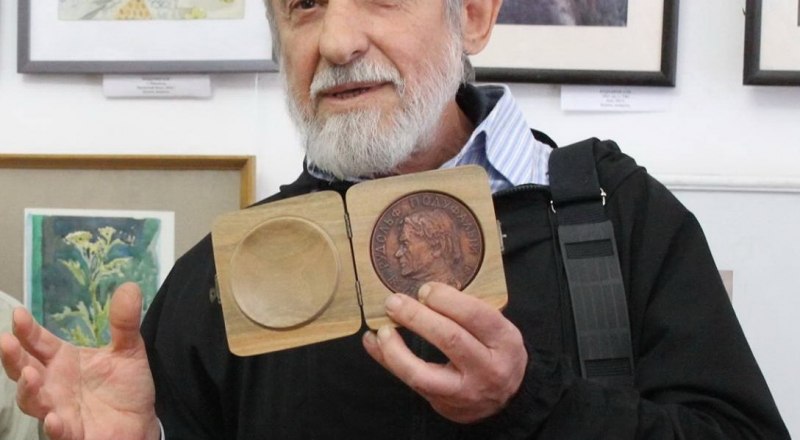 Александр Марьяхин вручает музею памятную медаль.