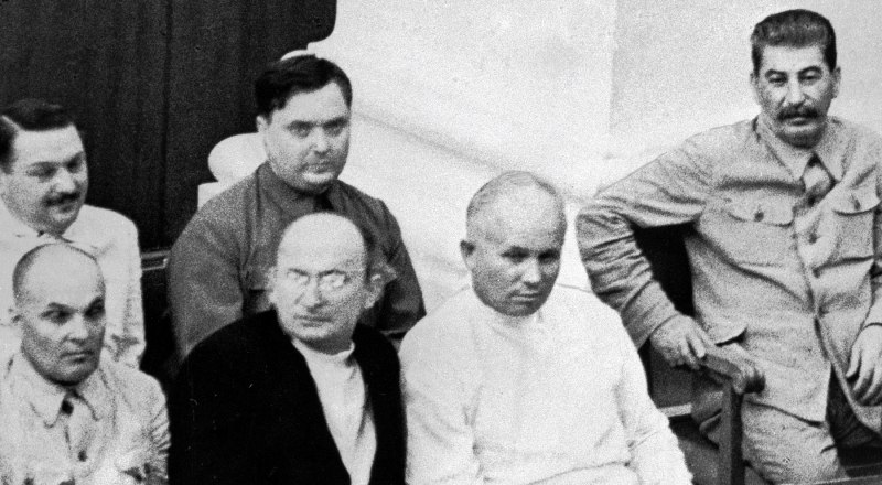 В первом ряду справа налево: Иосиф Сталин, Никита Хрущёв, Лаврентий Берия, Матвей Шкирятов. Во втором ряду справа налево: Георгий Маленков и Андрей Жданов.
