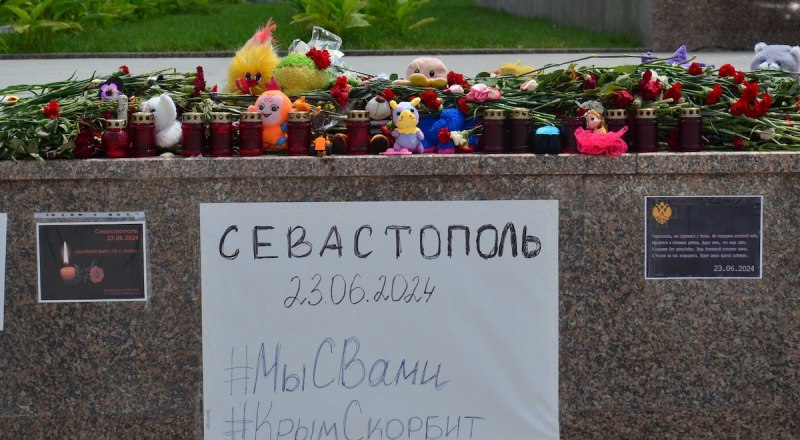 Крымчане продолжают нести цветы к стихийному мемориалу.