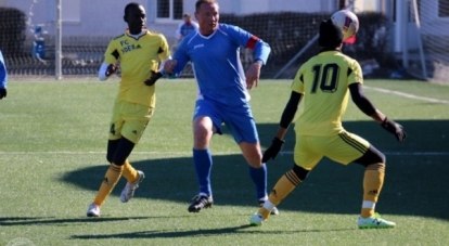 Капитан симферопольской «ТСК-Таврии» Антон Монахов (в тёмной форме) ведёт борьбу за мяч с камерунскими футболистами.