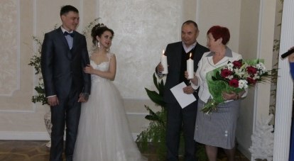 В самом большом в Крыму зале нового ЗАГСа супруги со стажем в 42 года передали свечи молодожёнам.