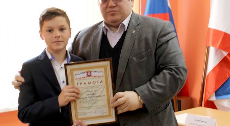 Олег Лобов вручает награду самому юному участнику конкурса - шестикласснику Николаю Попову, тому самому, что смог найти могилу прадеда.