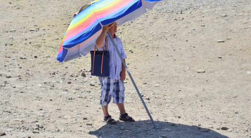 Во время полуденного пекла на пляже лучше не появляться - зонтик от теплового удара не спасёт.