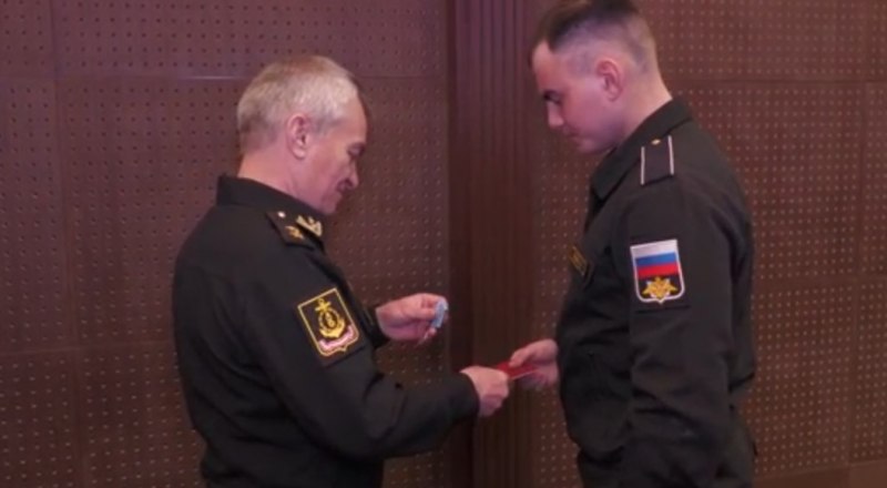 Командующий Черноморским флотом вице-адмирал Виктор Соколов вручает награду матросу Артёму Жильцову.
