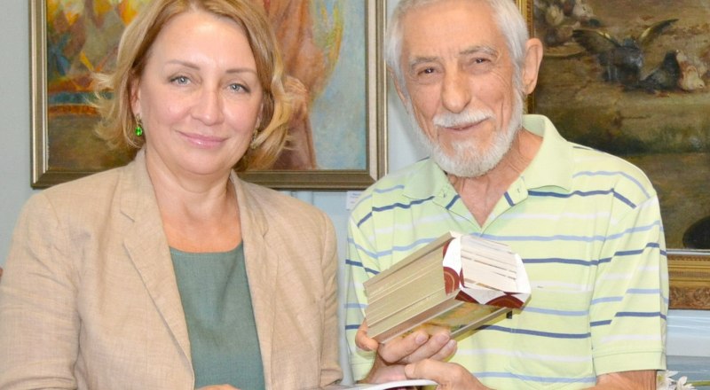 Александр Марьяхин передаёт директору комплекса алуштинских музеев Светлане Немирович комплект открыток со своими работами.